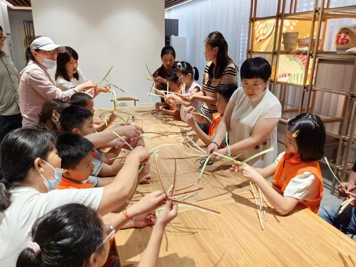 山東手造展示體驗(yàn)中心，博興草編傳承人張慧華帶孩子們體驗(yàn)草編技藝